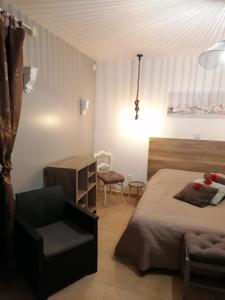 ein Schlafzimmer mit einem Bett, einem Stuhl und einem Tisch in der Unterkunft Chambre d'hotes Le Hamel in Le Hamel