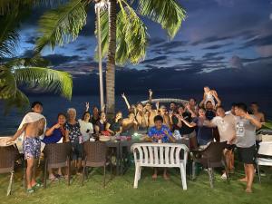 a group of people sitting at a table on the beach at Rio Beach Resort in Alegria