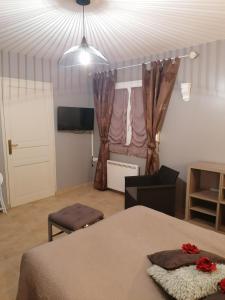 a bedroom with a bed and a room with a tv at Chambre d'hotes Le Hamel in Le Hamel