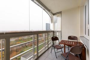 einen Balkon mit einem Tisch und Stühlen in einem Gebäude in der Unterkunft Rent like home - Słomińskiego 5 II in Warschau