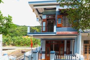 a house with a blue facade with a balcony at Cong Man Homestay Cham Island in Hoi An