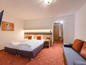 una camera d'albergo con letto e divano di Lifthotel a Kirchberg in Tirol