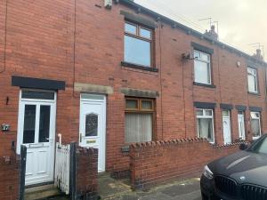 a red brick building with white doors and windows at Laura Ashley cosy inner terrace in Barnsley