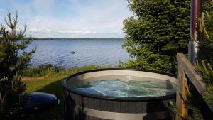 a hot tub with a view of a lake at Kauppilan Rantasauna in Ikaalinen +3 photos