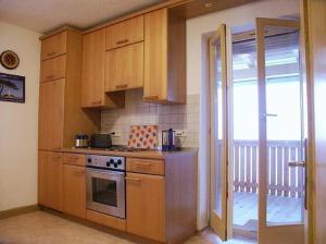 a kitchen with wooden cabinets and a stove top oven at Ferienwohnung Sigi's Waldhaus in Neuschönau