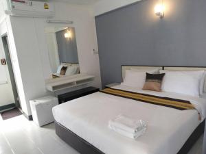 une chambre avec un grand lit blanc et un miroir dans l'établissement NorthLands House Hotel, à Chiang Mai