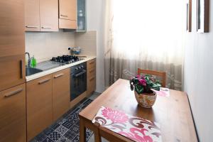 una cocina con una mesa de madera y un jarrón de flores en Casa Vacanza Via Roma, en San Giorgio Ionico