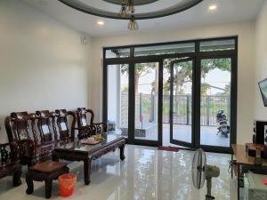 a living room with chairs and a table and sliding glass doors at VILLA CHÂU ĐỐC in áº¤p VÄ©nh ÃÃ´ng