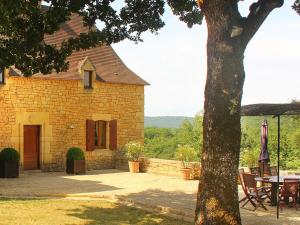 ceglany dom ze stołem i patio w obiekcie Chambre d'Hôtes La Rossillonie w mieście Beynac-et-Cazenac