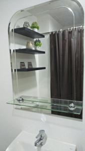 La salle de bains est pourvue d'un miroir, d'un lavabo et d'un rideau de douche. dans l'établissement La Suerte Condo at SMDC Tagaytay, à Tagaytay