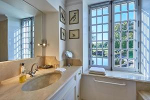 a bathroom with a sink and a large window at Manoir de Cléronde - B&B in Blay