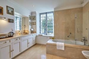 un ampio bagno con vasca e lavandino di Manoir de Cléronde - B&B a Blay