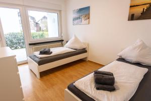 1 dormitorio con 2 camas y ventana en Schöne 3-Zimmerwohnung mit WLAN, en Büsingen