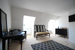 ein Wohnzimmer mit einem Tisch, einem Stuhl und einem Schreibtisch in der Unterkunft Riddersviks Herrgård in Stockholm