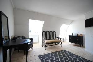 a living room with a table and a chair and a desk at Riddersviks Herrgård in Stockholm