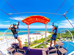 two people riding on a zip line at a resort at Sheraton Okinawa Sunmarina Resort in Onna