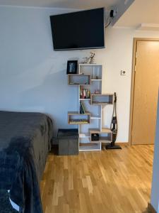 a bedroom with a bed and a tv on a wall at Oja tn 118 Apartment-Free parking in Pärnu