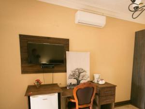 a room with a desk with a television and a chair at Ein Gedi Premier Weddings And Conferences in Kimberley