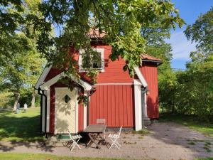 einem roten Schuppen mit einer Bank davor in der Unterkunft Riddersviks Herrgård in Stockholm