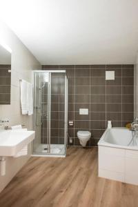 een badkamer met een douche, een bad en een toilet bij GAMA Home in Fribourg