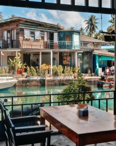 a house on the water with a table and chairs at Baan Rabieng Talay Homestayบ้านระเบียงทะเล โฮมสเตย์เกาะกูด in Ko Kood