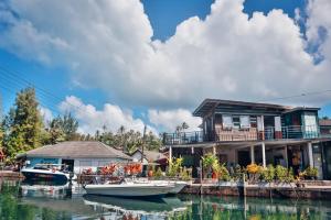 a house on a dock with boats in the water at Baan Rabieng Talay Homestayบ้านระเบียงทะเล โฮมสเตย์เกาะกูด in Ko Kood