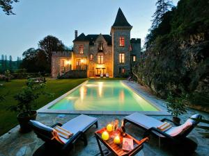 an estate with a swimming pool in front of a house at manoir de la malartrie in Vézac