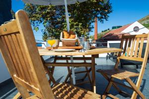 a wooden table with a bowl of food and an umbrella at Mateus House - Porto da Cruz Center in Porto da Cruz