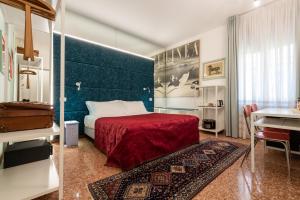 a bedroom with a bed with a red blanket and a table at Casa Bertagni in Bologna