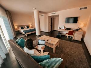 a woman sitting on a couch in a living room at Hotel Molo in Sopot