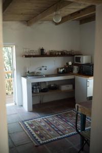 a room with a kitchen with a counter and a rug at The Whitehouse in Barrydale
