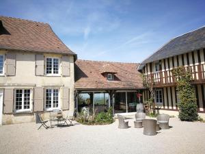a building with a courtyard with a bench in front of it at les marronniers in Cambremer
