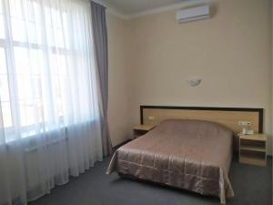 a bedroom with a bed and a large window at Baza Otdykha Kazaki in Aleksandrovka