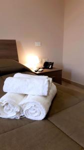 a bed with white towels on it with a desk at Tenuta Terra Tefra in Conca della Campania