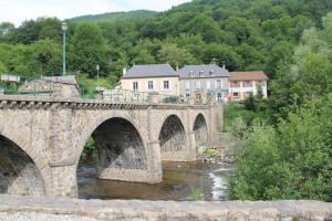 un puente de piedra sobre un río en una ciudad en la violette, en Ferrières-Saint-Mary