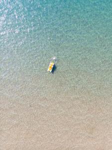 a small boat floating on top of a body of water at Resort Riva Degli Etruschi in San Vincenzo