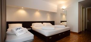a bedroom with two beds with towels on them at Astoria Resort in Riva del Garda