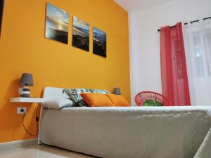 a living room with a couch and a yellow wall at 23 DE ENERO in La Restinga