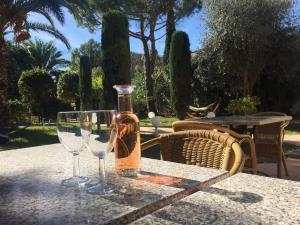una bottiglia di vino e due bicchieri di vino su un tavolo di Le Jardin d'Homps a Homps