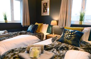 ein Schlafzimmer mit 2 Betten mit Kissen darauf in der Unterkunft 4 Bedroom House -Sleeps 12- Big Savings On Long Stays! in Canterbury