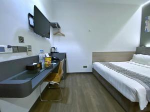 a hotel room with a bed and a television at Bliss Hotel Singapore in Singapore