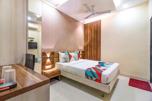 um quarto com uma cama e uma secretária em FabHotel Grand Heritage Kurla West em Mumbai