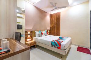 a bedroom with a bed and a desk at FabHotel Grand Heritage Kurla West in Mumbai