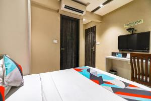 a bedroom with a bed and a flat screen tv at FabHotel Grand Heritage Kurla West in Mumbai