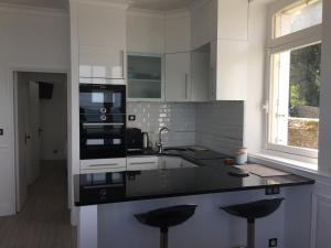 una cocina con encimera negra y fregadero en Villa XIXe Vue mer, en Dinard