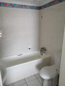 a bathroom with a white tub and a toilet and a sink at Seagull 404 in Margate