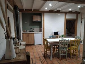 eine Küche und ein Esszimmer mit einem Tisch und Stühlen in der Unterkunft La résiniere de pirique in Parentis-en-Born