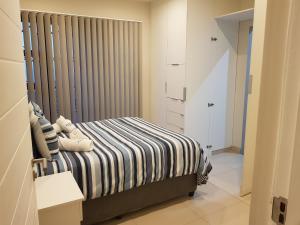 a bedroom with a bed with a striped blanket at Westbrook Cabanas 1st in Westbrook +2 photos