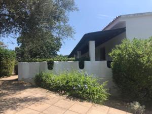 a white fence in front of a house at White Sand Residence in Murta Maria