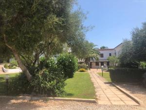 a yard with a tree and a house at White Sand Residence in Murta Maria